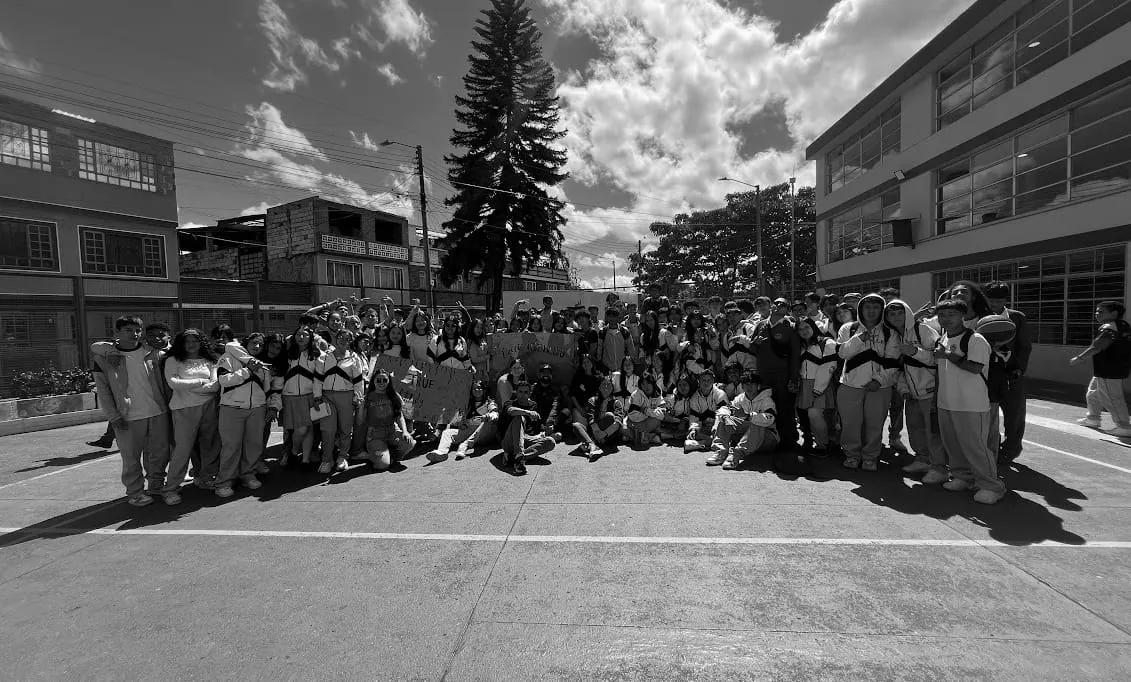 A group of young people in a school courtyard, gathered in community